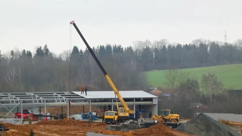 Construction work on a building site with a crane and workers in a rural area du Stock Footage 323953668