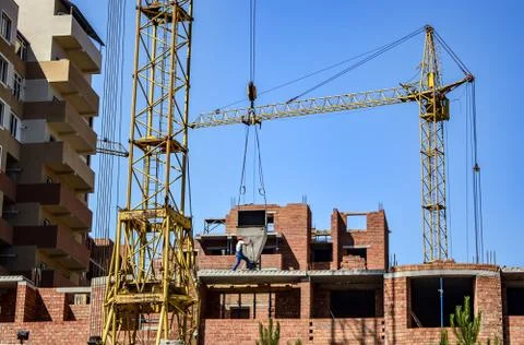 Construction work with a crane against the blue sky Stock Photos