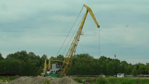 Construction work with crane and dirt pile at industrial site near river on a cl Vídeo Stock 340447948