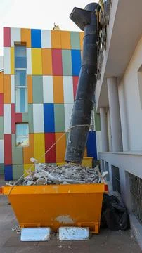 Construction work with dumpster and rubble chute at a building site in an u.. Photos