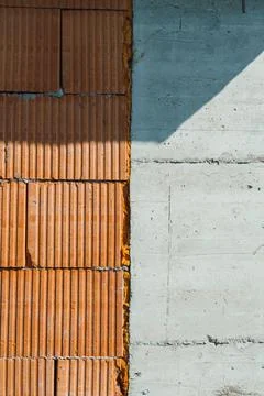 Construction work features orange bricks placed next to gray concrete. Sunlig Stock Photos