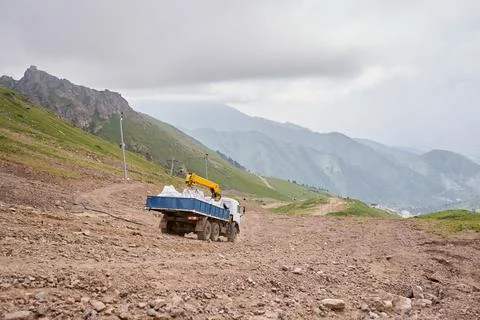 Construction Work in the highlands. Transportation by dump manipulator trucks Stock Photos