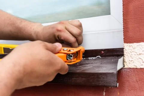 Construction work - installation of rivets. Window tint repair. Plastic windows. Stock Photos