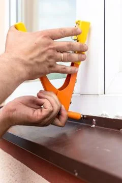 Construction work - installation of rivets. Window tint repair. Plastic windows. Stock Photos