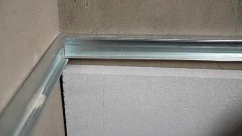 Construction work installing metal profile on concrete block wall Stock Photos