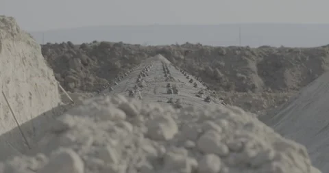 Construction work, iron pipe, laying communications, earth trench, stones Stock Footage 305641067