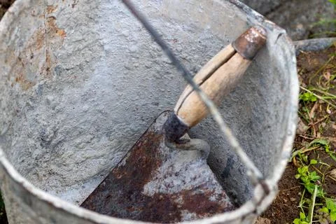 Construction work. Knead the cement. Cement. Use cement from a bucket Stock Photos