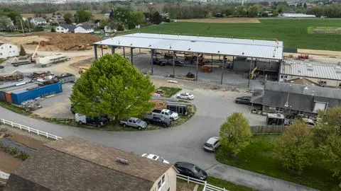 Construction Work on Large Building in Rural Area Near Residential Houses Stock Photos