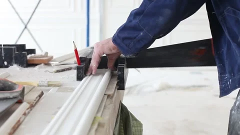 Construction work, man sawing ceiling cornice, red pencil, finishing work Stock Footage 303406696