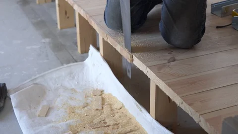 Construction work - a man sawing sawn wooden floor boards Stock Footage 106277357