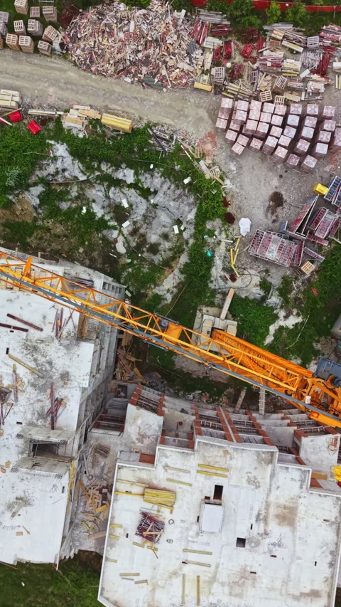 Construction work on a multi-storey building with cranes and materials on site Stock Footage 337909966