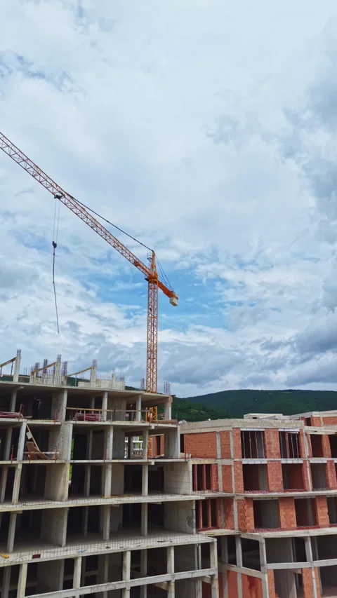Construction work on a multi-storey building with a crane and cloudy sky in the Stock Footage 337915109