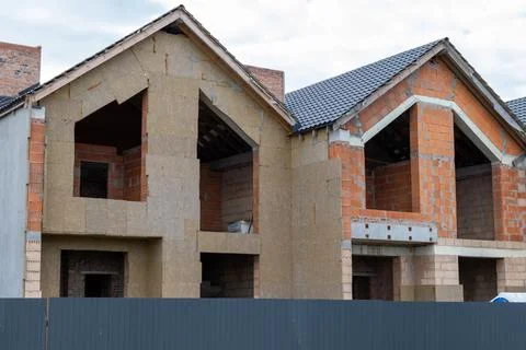 Construction work is ongoing on houses as builders use bricks and insulatio.. Stock Photos