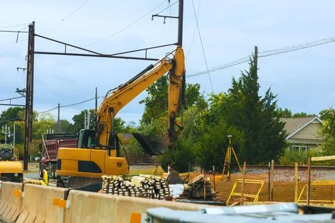 Construction work is ongoing near train tracks with heavy machinery Stock Photos
