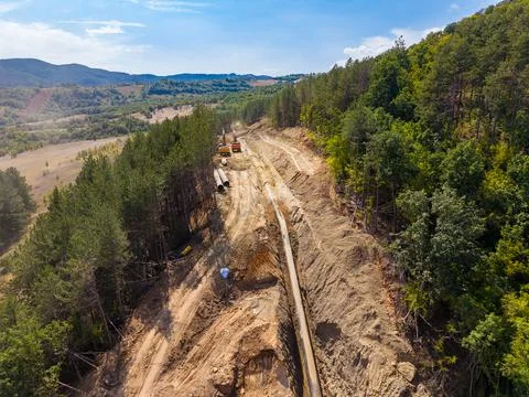 Construction work on a pipeline project in a rural area surrounded by trees.. Stock Photos