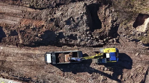 Construction work in progress at a site with a digger loading dirt into a truck Stock Footage 331162772