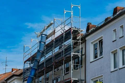 Construction work on a residential building under clear blue sky Stock Photos