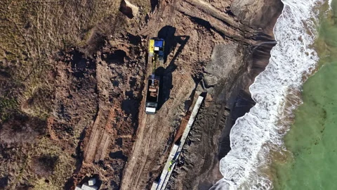 Construction work on the shoreline for beach restoration project during daylight Stock Footage 336552675