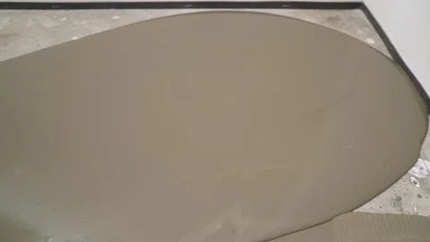 Construction work on the sidewalk. A worker pours concrete mortar onto a pr.. Stock Photos