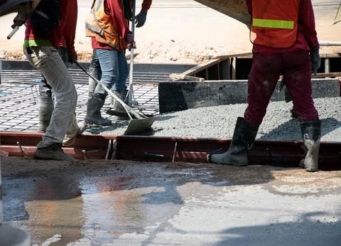 Construction work is still ongoing, such as pouring concrete. Stock Photos