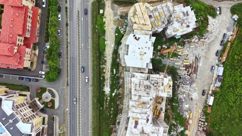 Construction work takes place alongside a busy road with buildings and empty Stock Footage 340148924