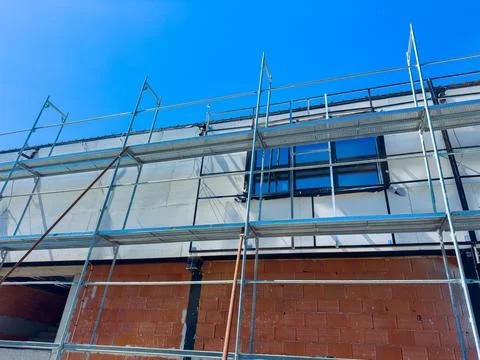 Construction work takes place on a building with scaffolding on a bright da.. Stock Photos