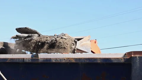 Construction work takes place with heavy machinery breaking concrete Stock Footage 337138390