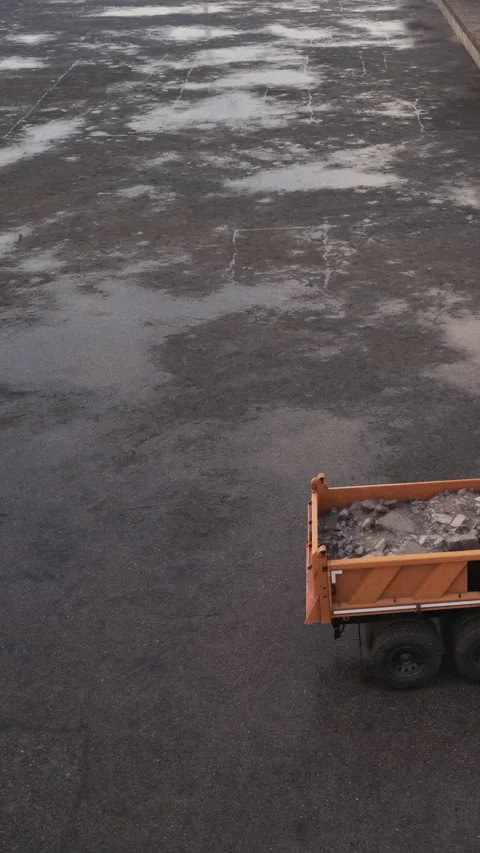 Construction work takes place on a paved road with a truck at a job site Stock Footage 340634164