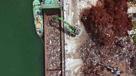 Construction work takes place at a recycling facility along a river with heavy Stock Footage 340151826