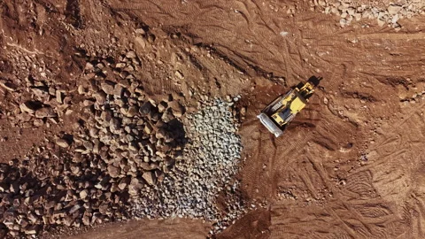 Construction work takes place at a site with rocks and heavy machinery moving Stock Footage 340148477