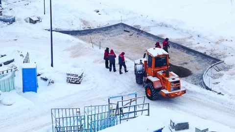 Construction work takes place in the snowy area with workers and machinery on a Vídeo Stock 328486988