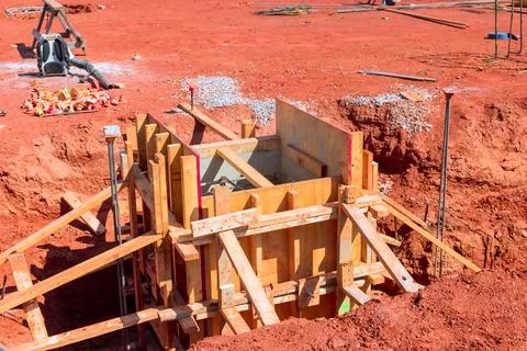 Construction work taking place at building site with concrete forms, wooden 스톡 사진