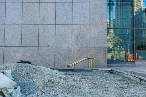 Construction work is taking place near a building with a large wall and a v.. Stock Photos
