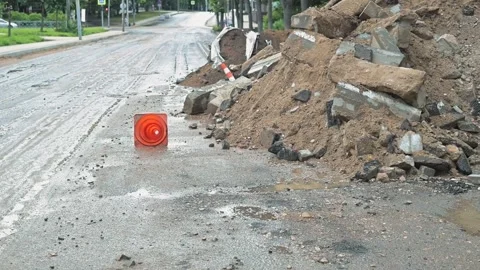 Construction work is taking place on a street where large piles of dirt and 库存影片 344667147