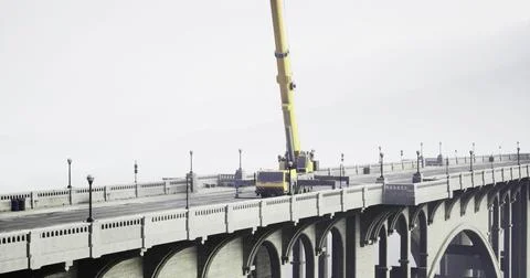 Construction work underway on a bridge with a crane lifting heavy materials Stock Illustration