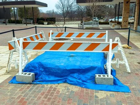 Construction work is underway at a public area with a safety barrier and ta.. Stock Photos