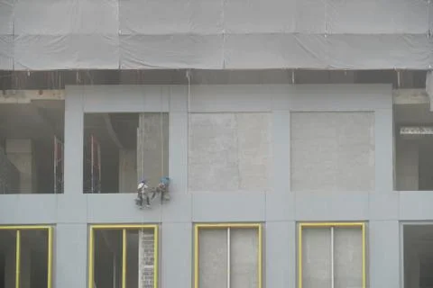 Construction worker abseiling plastering two people Stock Photos