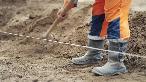 A construction worker is actively using a tool during an essential digging Stock Footage 312634777