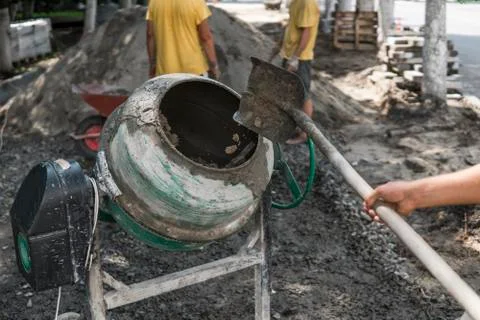 Construction worker add ingredients for mixing in the concrete mixer at building Stock Photos