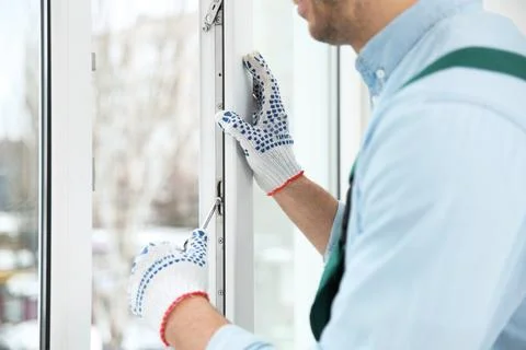 Construction worker adjusting installed window with screwdriver indoors, clos 스톡 사진