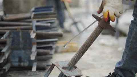 Construction worker adjusting metal support prop on building site Stock Footage 323434172