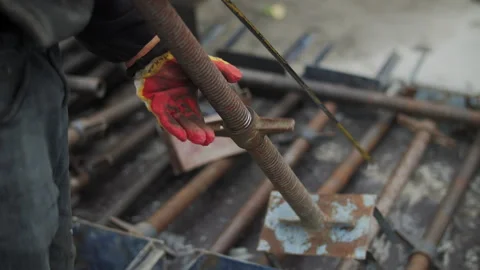 Construction worker adjusting metal support prop at building site Stock Footage 323434236
