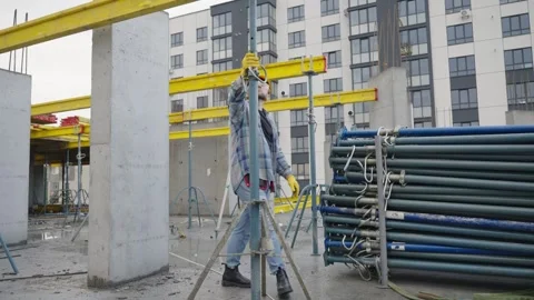 Construction worker adjusting scaffolding prop on building site Vídeos de archivo 337470050