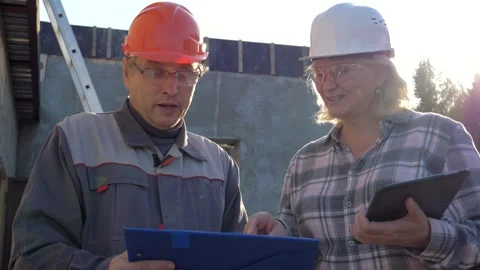 Construction worker and architect discussing project plans on building site Video stock 316259458