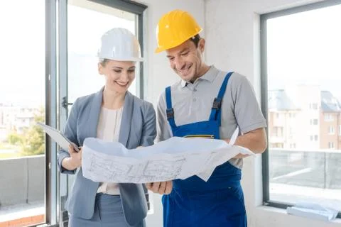 Construction worker and architect looking at plan on site Stock Photos