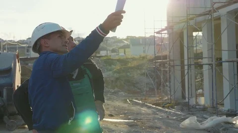 Construction worker and engineer talking at construction site site Stock Footage 83402352