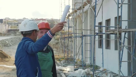 Construction worker and engineer talking at construction site site Stock Footage 83402377
