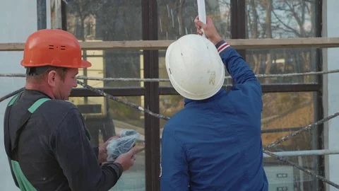 Construction worker and engineer talking at construction site site, rear view. Stock Footage 83402768