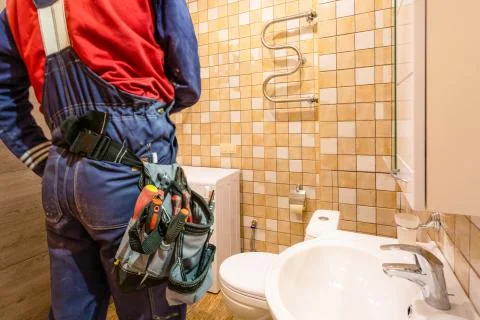 Construction worker and plumber with workwear and tool bag with tools on the Stock Photos