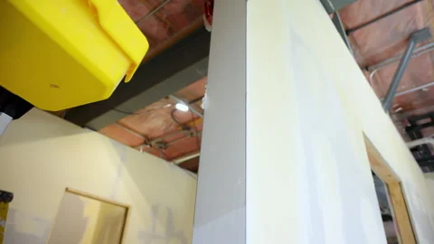 Construction worker applies joint compound to drywall end using a metal spatulas Stock Footage 320263326